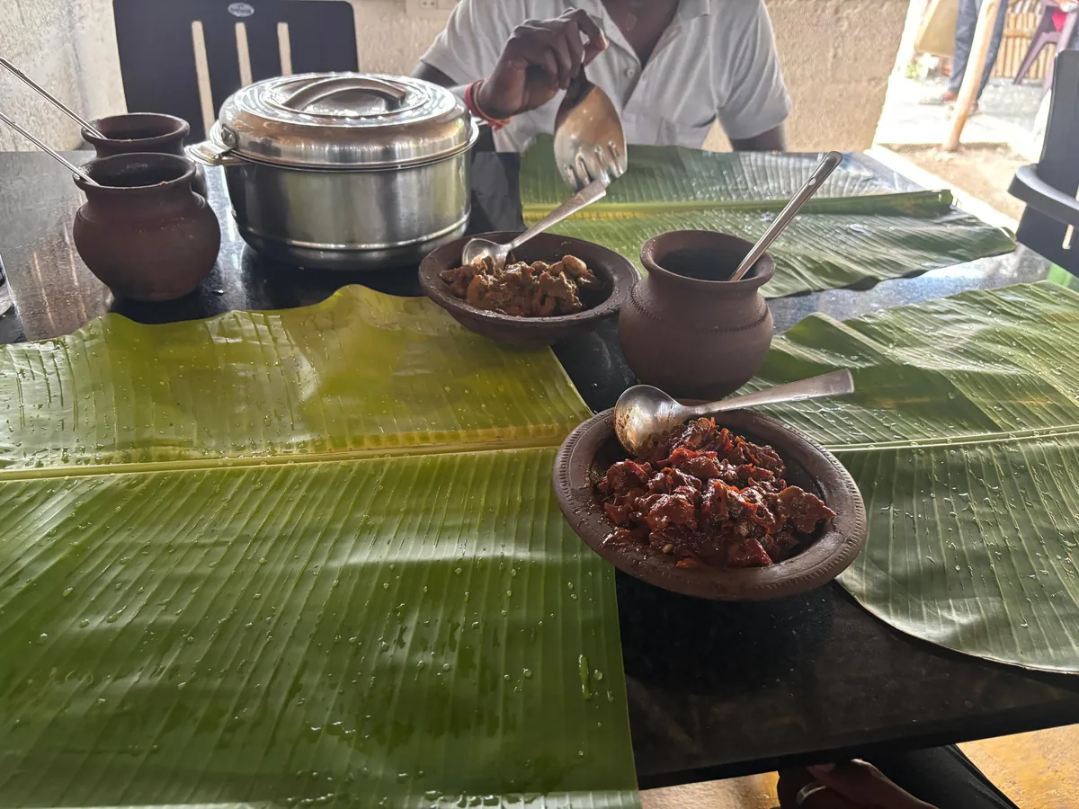 A traditional meal served with banana leaves and clay bowls